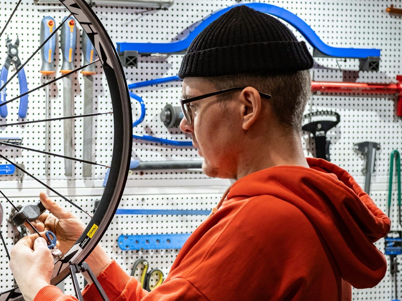 Un mecánico centra una rueda en su taller de bicicletas